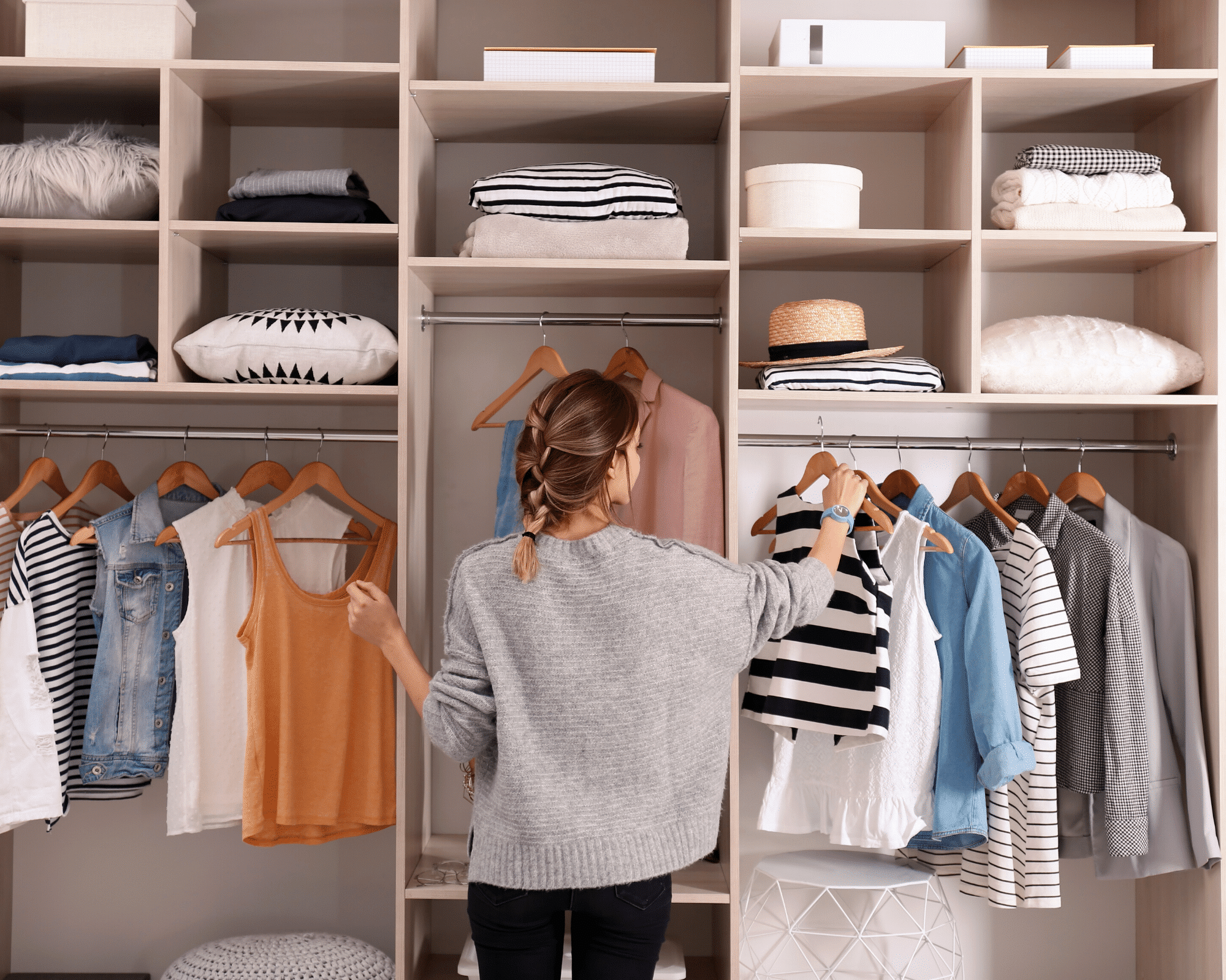 Wie man seinen Kleiderschrank ausmistet 2 Frau in ihrem Kleiderschrank, die sich entscheidet, was sie anziehen soll