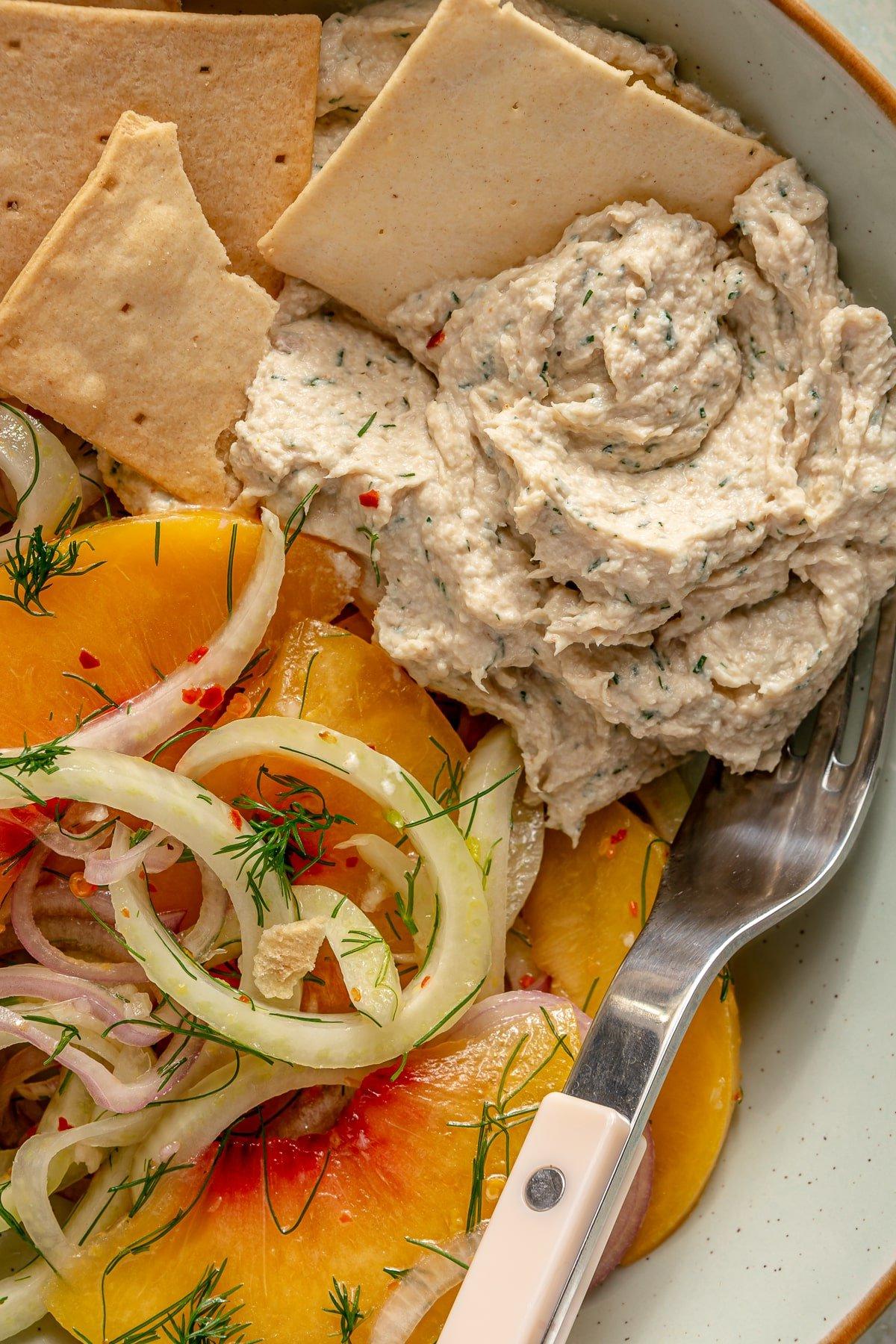 Zitronen-Dill-Hähnchensalat 2 Ein samtig-glatter Zitronen-Dill-Hähnchensalat, serviert neben einem Nektarinensalat und Crackern.