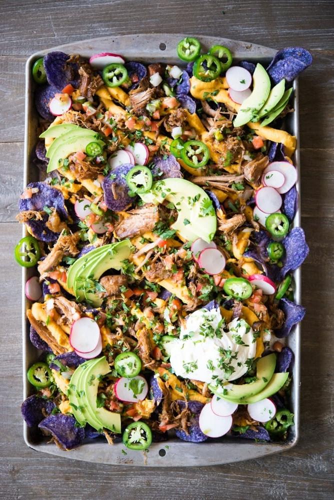 Eine großzügig belegte Portion Carnitas Nachos mit geschmolzenem Käse, Pico de Gallo und weiteren Toppings.