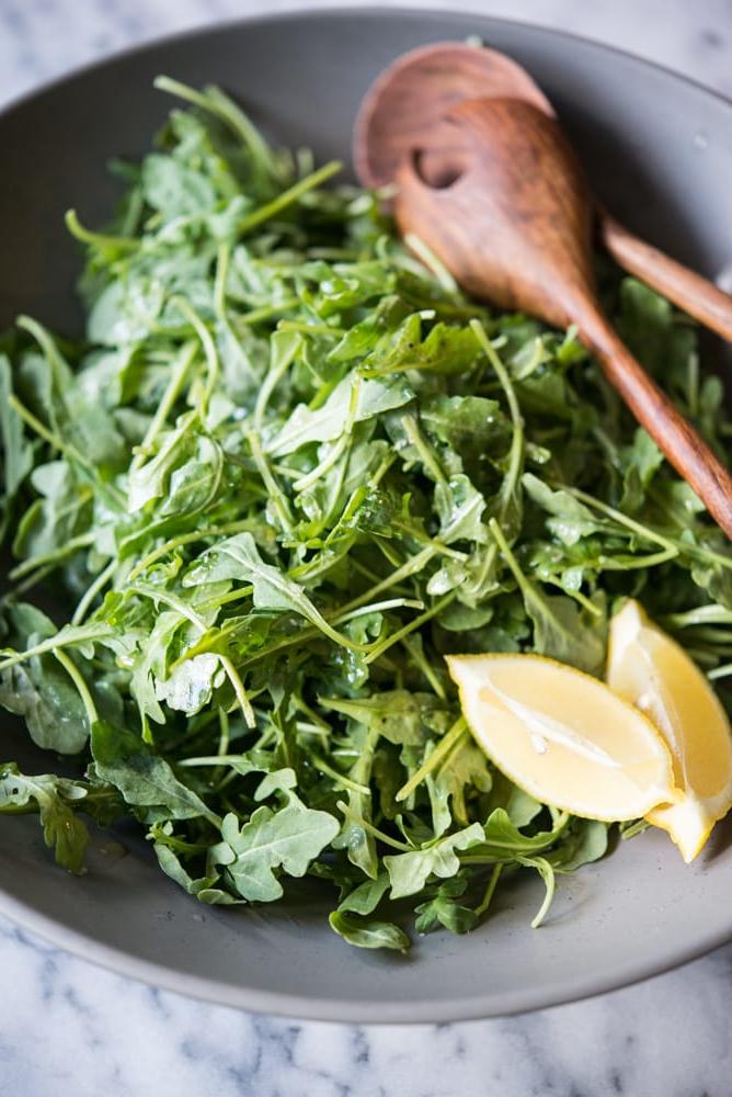 Rucola Salat mit Zitrone und Meersalz 2 Frischer Rucola Salat mit Zitronenspalten und Meersalz bestreut