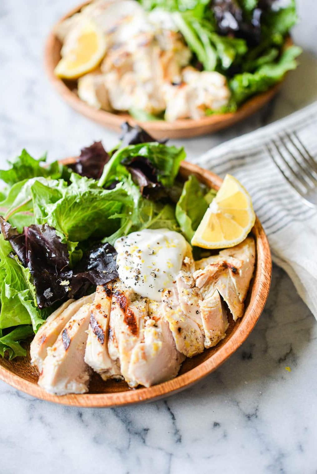Zitronenpfeffer-Joghurt-Grillhähnchen 5 Geschnittenes Zitronen-Pfeffer-Joghurt-Hähnchen vom Grill, serviert in einer Schale auf gemischtem Salat