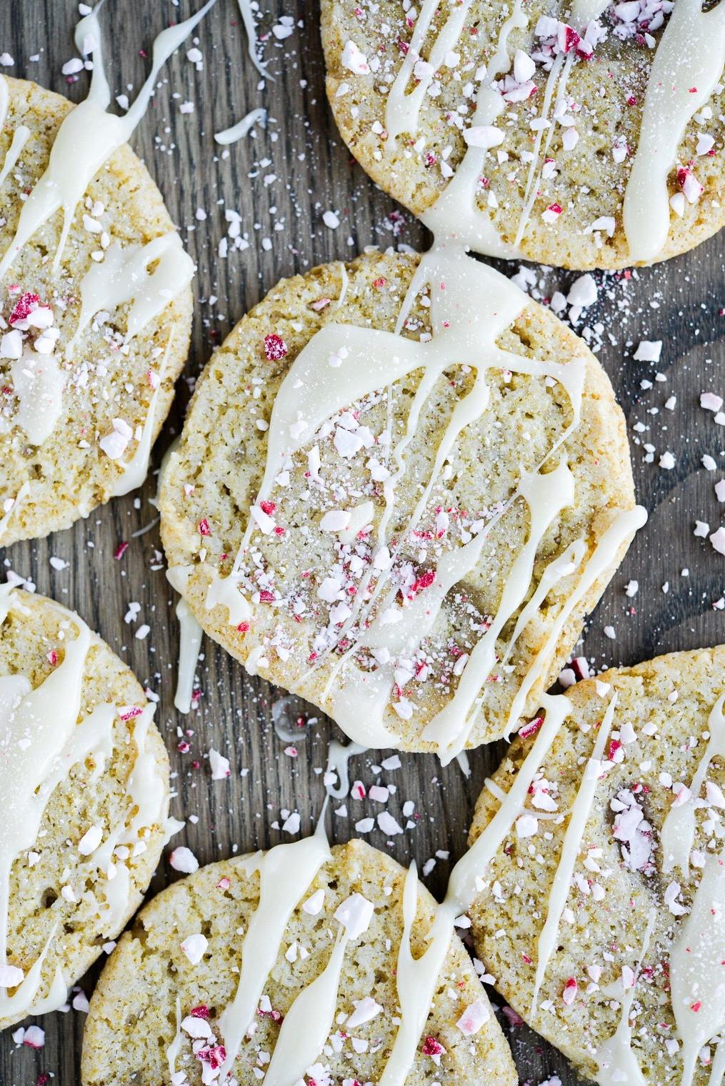 **Weiße Schokoladen-Pfefferminz-Kühlschrankkekse** 12 Fertige Zuckerkekse mit weißer Schokolade überzogen und zerstoßenen Pfefferminz auf einer Holzoberfläche