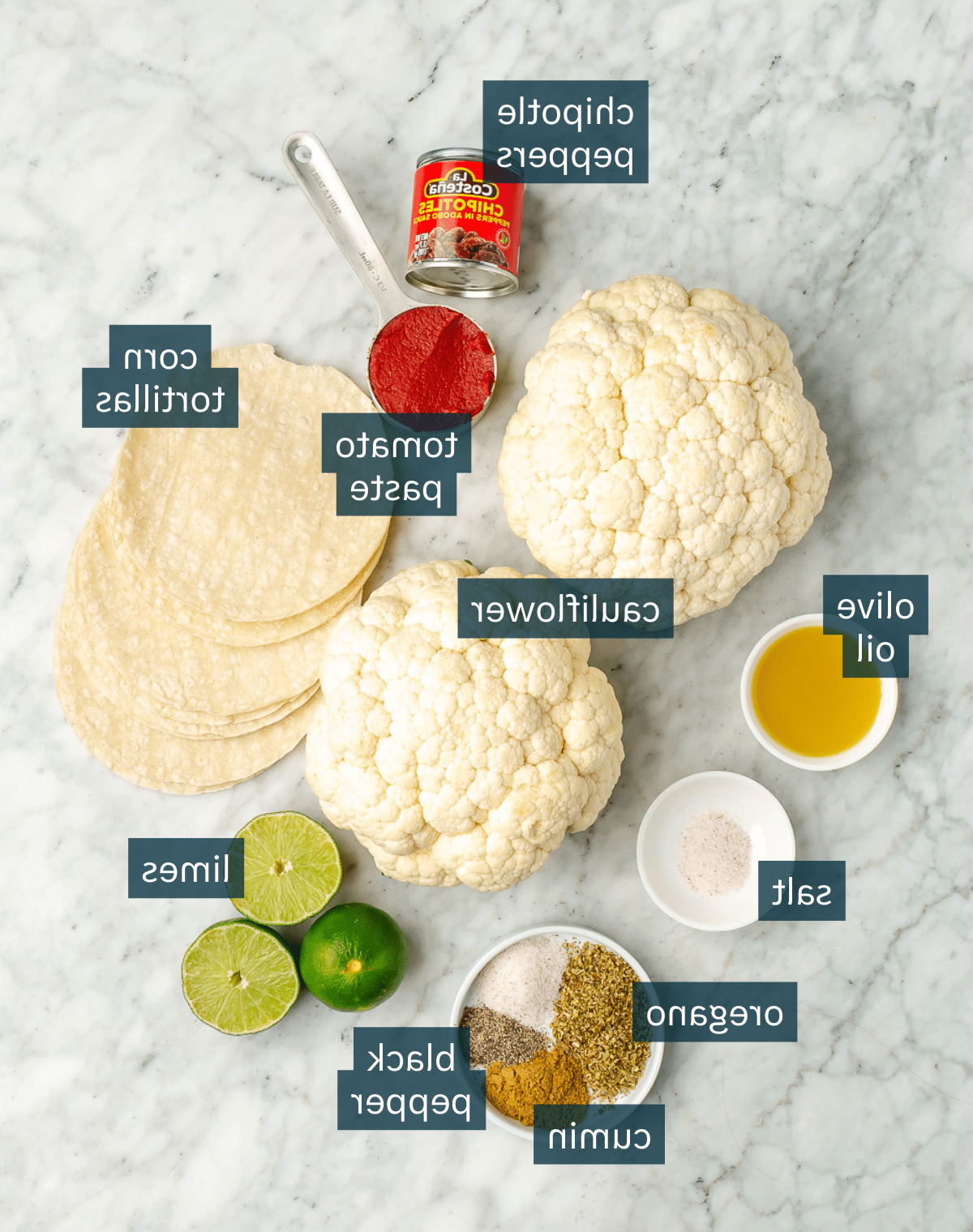Knusprige Blumenkohl-Tinga-Tacos 3 Alle Zutaten für Blumenkohl-Tinga-Tacos auf einer Marmoroberfläche.