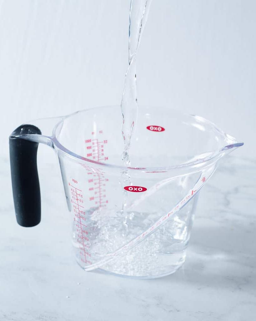 210920_How to Soften Butter-10 Eine Person gießt Wasser in einen Messbecher