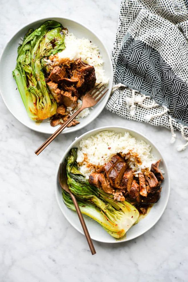 Teriyaki Schweinefilet aus dem Schongarer 3 Zwei flache Schüsseln mit weißem Reis, Teriyaki-Schweinefilet und Pak Choi