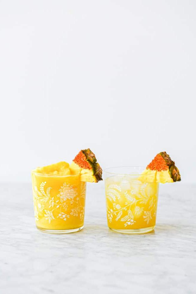Die beste Ananas-Margarita (2 Varianten!) 3 Zwei Margarita-Gläser (eins mit gefrorenem Ananas Margarita und eins mit Ananas Margarita auf Eis), garniert mit einem in Chili-Salz getauchten Ananas-Keil.