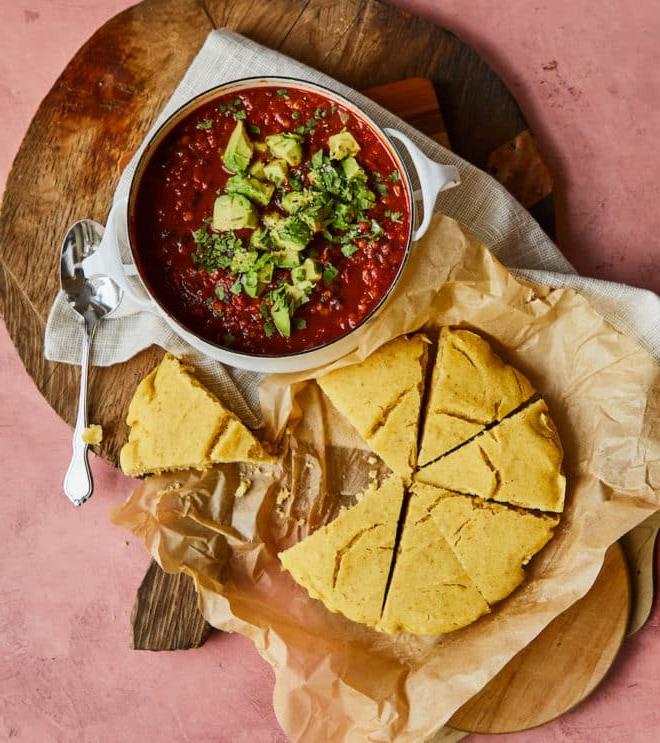 Zwei Abendessen mit schwarzen Bohnen 4 Vegetarisches Chili neben einer Portion veganem Maisbrot