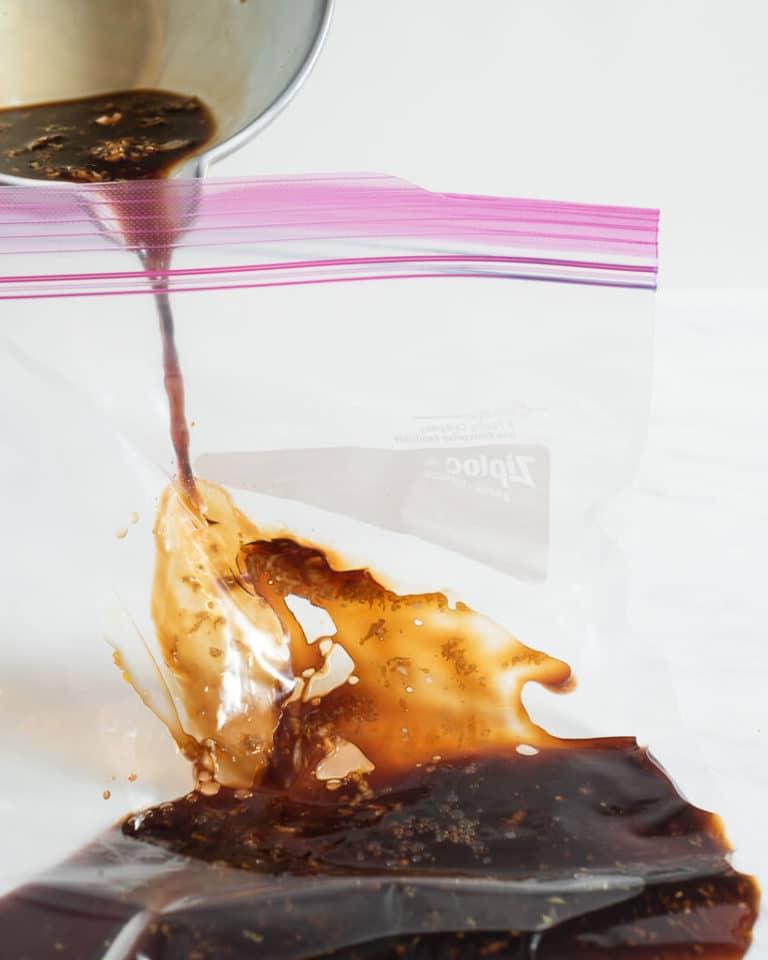 Eine Person gießt eine Grillhähnchen-Marinade in einen großen Zipper-Beutel
