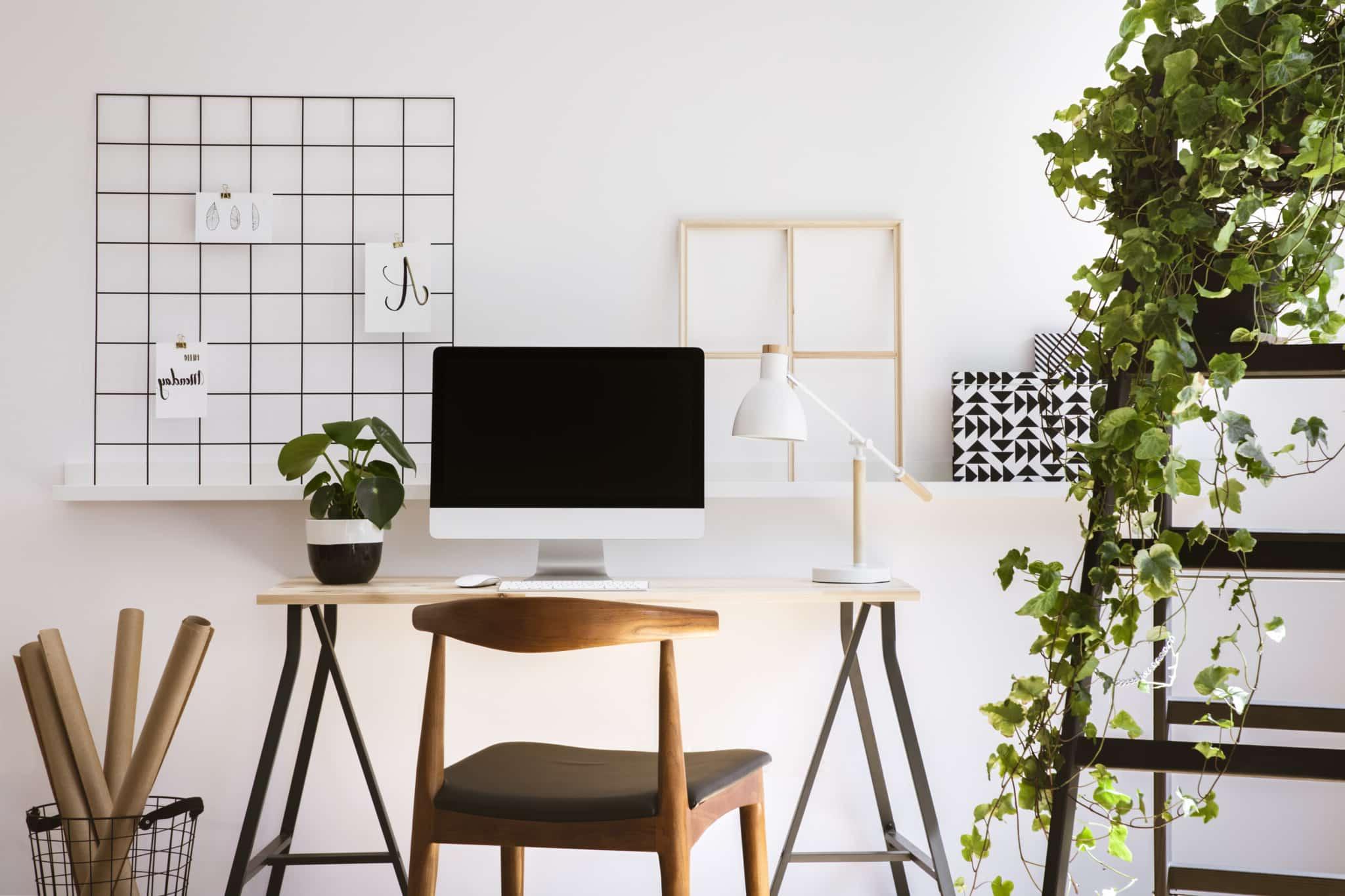 10 Tipps, um im Home-Office gesund zu bleiben 4 office with a white desk, mac monitor, wooden chair, and a shelf with a plant on it