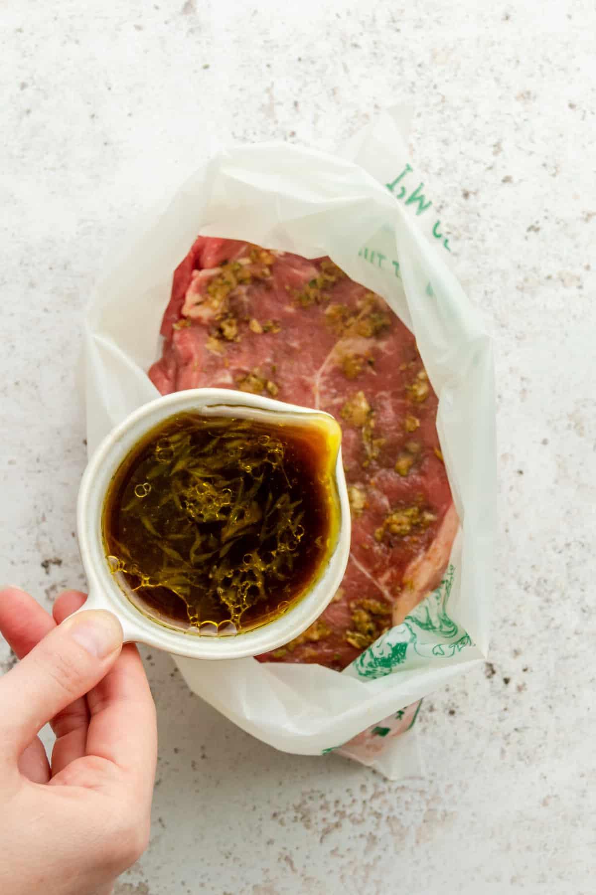 Carne Asada Tacos Rezept mit Adobo-Limetten-Marinade 5 Eine Limettenmarinade wird über adobo-gewürztes Steak in einem Ziploc-Beutel auf einer hellgrauen Oberfläche gegossen.