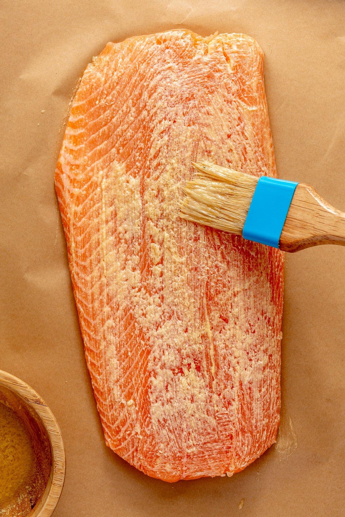 Lachs mit Parmesankruste 5 Lachsfilet auf Backpapier, die Oberseite wird mit Butter-Senf-Mischung bestrichen.