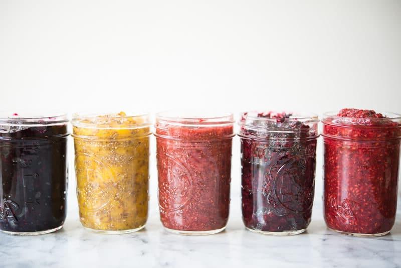 5 Einmachgläser mit verschiedenfarbiger Chia-Marmelade, seitliche Ansicht