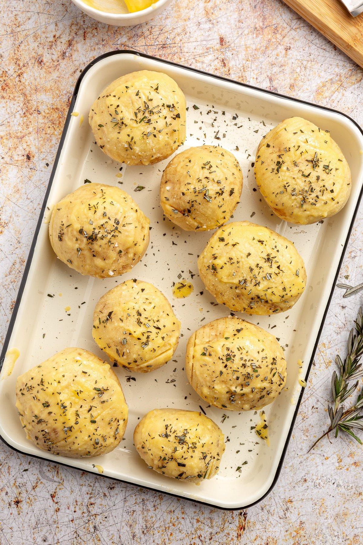 Hasselback-Kartoffeln mit Rosmarin 6 Eine Vielzahl von gehackten Kräutern wurde über die geschnittenen Kartoffeln gestreut.