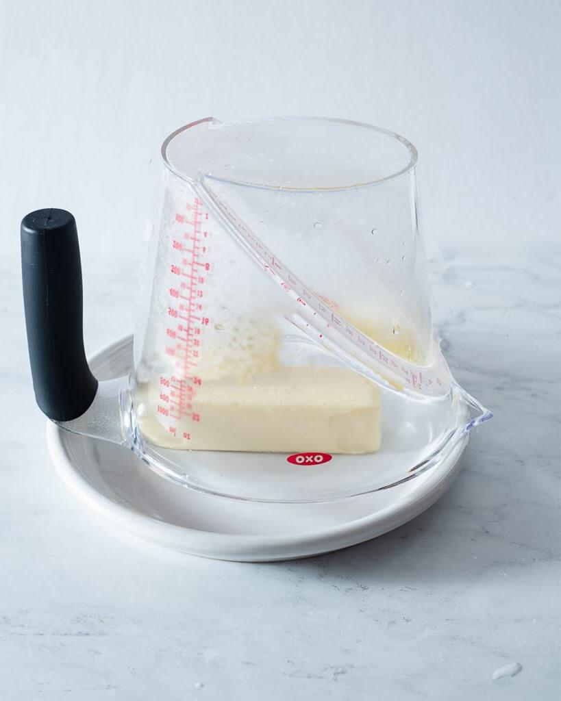210920_How to Soften Butter-13 Ein dampfender Messbecher umgedreht über einem Stück Butter