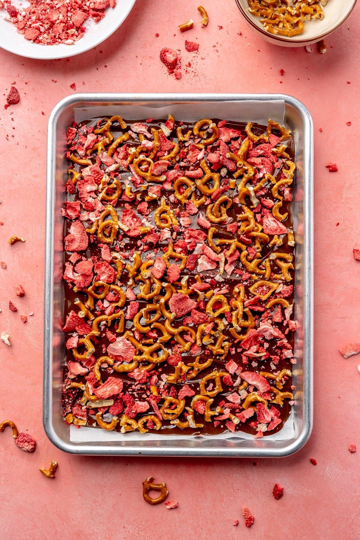 Gefriergetrocknete Erdbeeren und zerbrochene Brezelstücke wurden über die Schokoladenschicht gestreut.