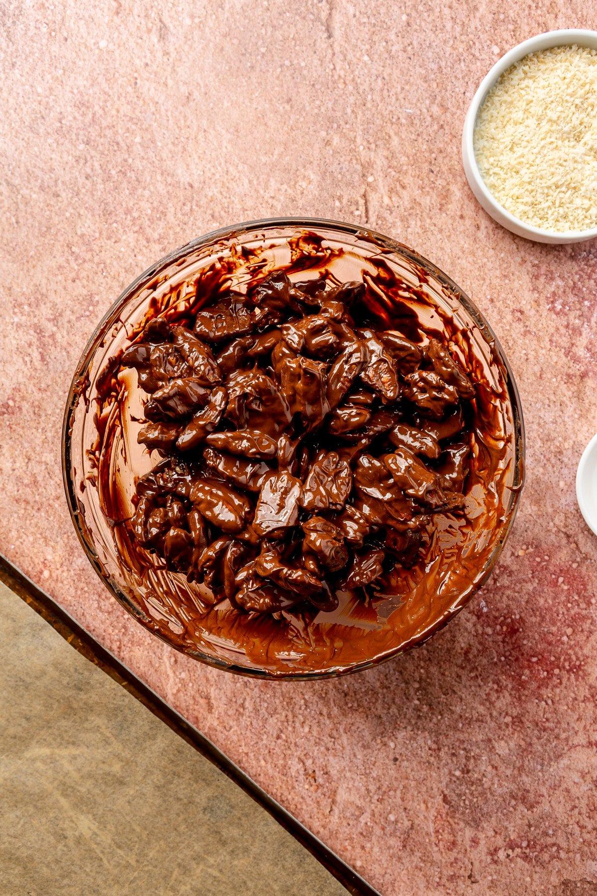 Ganze Pekannus-Hälften werden in die Schüssel mit der geschmolzenen Schokoladen-Chili-Mischung gegeben.