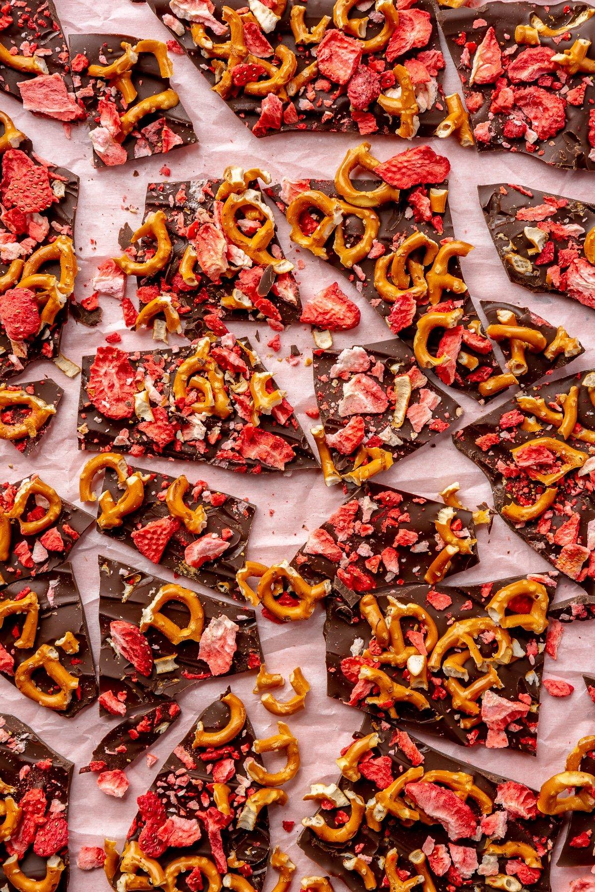 Dunkle Schokoladenrinde mit Erdbeeren und Brezeln wurde vom Backblech genommen und in Stücke gebrochen.