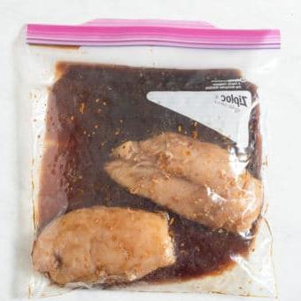 2 rohe Hähnchenbrüste in einem großen Zipper-Beutel mit Grillhähnchen-Marinade