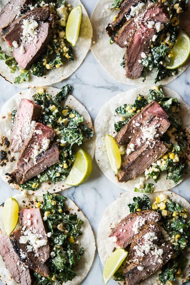 Carne Asada Tacos Rezept mit Adobo-Limetten-Marinade 8 Rindfleisch Carne Asada auf Grünkohl und Krautsalat in einer Maistortilla auf einem Marmorbrett