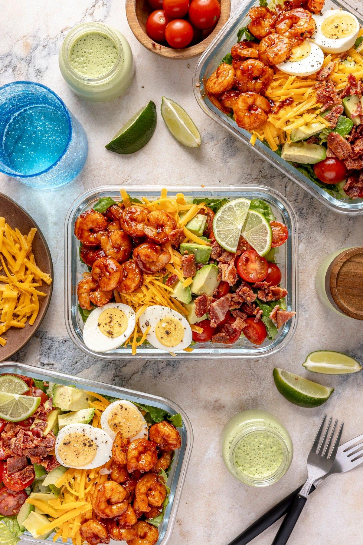 Scharfer Honig-Garnelen-Cobb-Salat 8 Ein Glas-Meal-Prep-Behälter gefüllt mit scharfem Garnelen-Cobb-Salat.