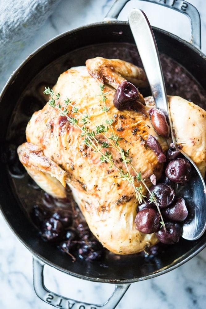 **Kirsch-Balsamico-Ofenhähnchen** 8 Tranchiertes Kirsch-Balsamico-Hähnchen mit Kirschen und Kräutern angerichtet.