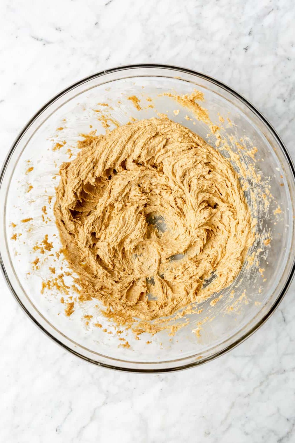 220817_Rum Raisin Cookies-17 Draufsicht auf Butter und Zucker, die in einer Glasschüssel cremig geschlagen werden.