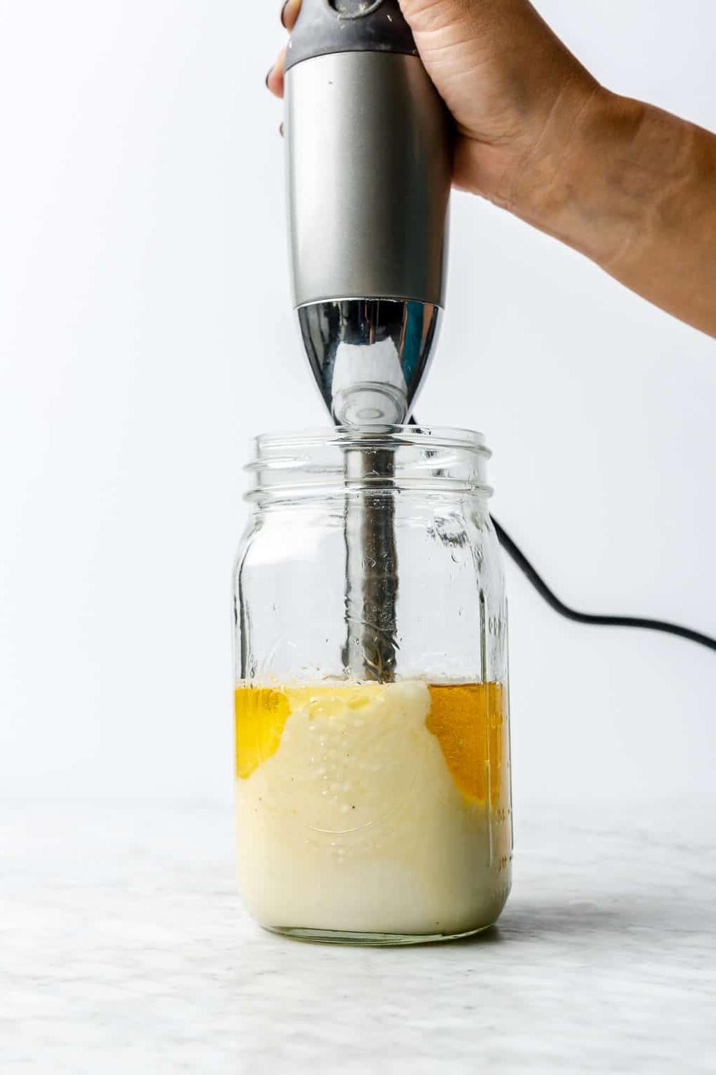 Zubereitungsschritt 6: Mayonnaise fertig mixen Hand, die einen Stabmixer in einem großen Einmachglas hält und die hausgemachte Mayonnaise püriert.
