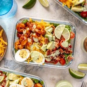 Scharfer Honig-Garnelen-Cobb-Salat 9 Ein Glas-Meal-Prep-Behälter gefüllt mit scharfem Garnelen-Cobb-Salat.