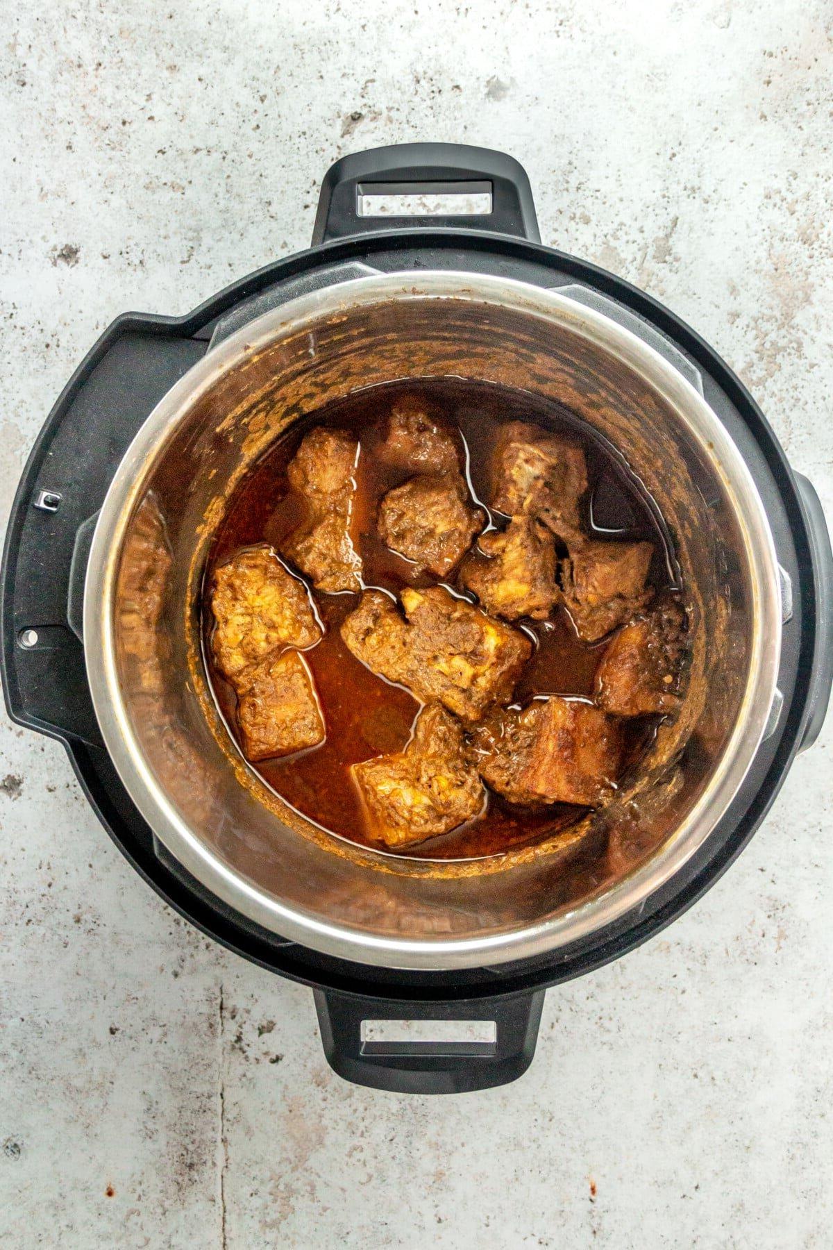 Tacos Al Pastor Rezept 10 Gekochte, perfekt zarte Stücke von mariniertem Schweineschulterfleisch im Slow Cooker nach dem Garvorgang.