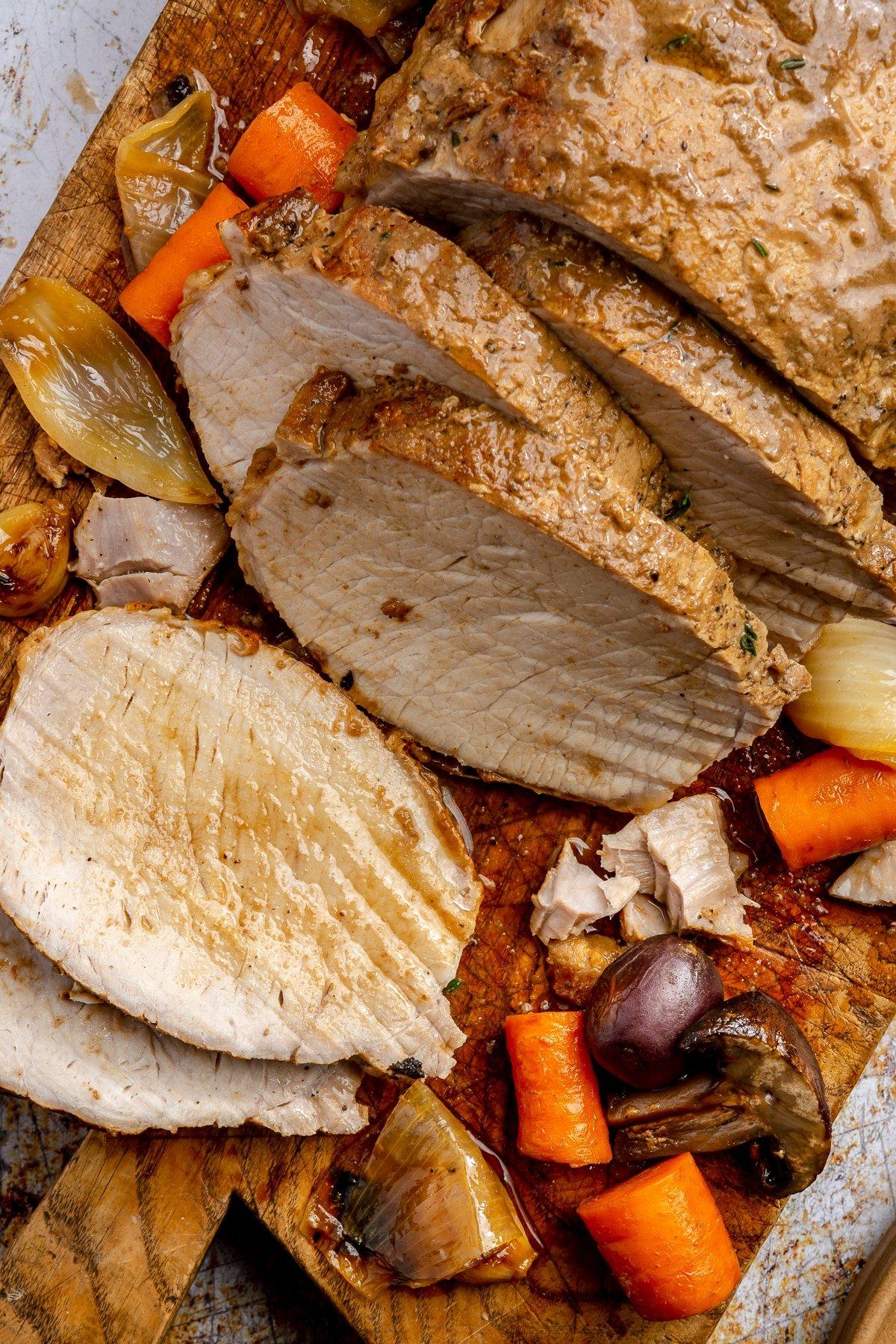 **Balsamico-Schweinelendenrezept** 10 Der Schweinebraten wurde in Scheiben geschnitten und liegt auf einem braunen Schneidebrett.