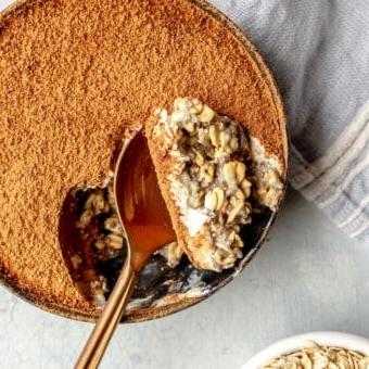 Tiramisu Overnight Oats 6 Draufsicht auf eine Schale Overnight Oats, aus der ein Löffel voll entnommen wurde.