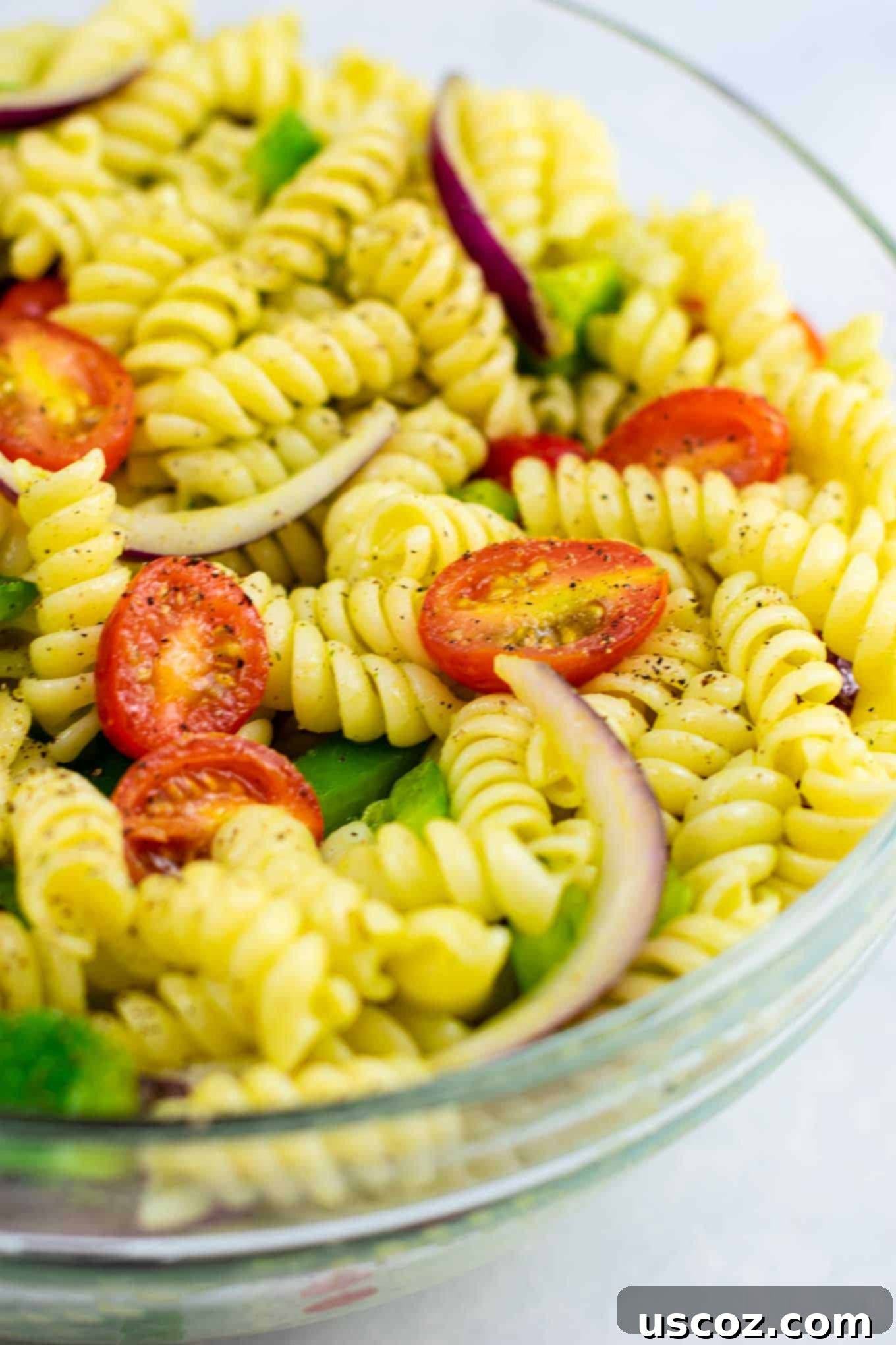 Vegan Pasta Salad 3 Rotini pasta being rinsed with cold water in a colander, a key step for preparing cold pasta salad to maintain its texture.