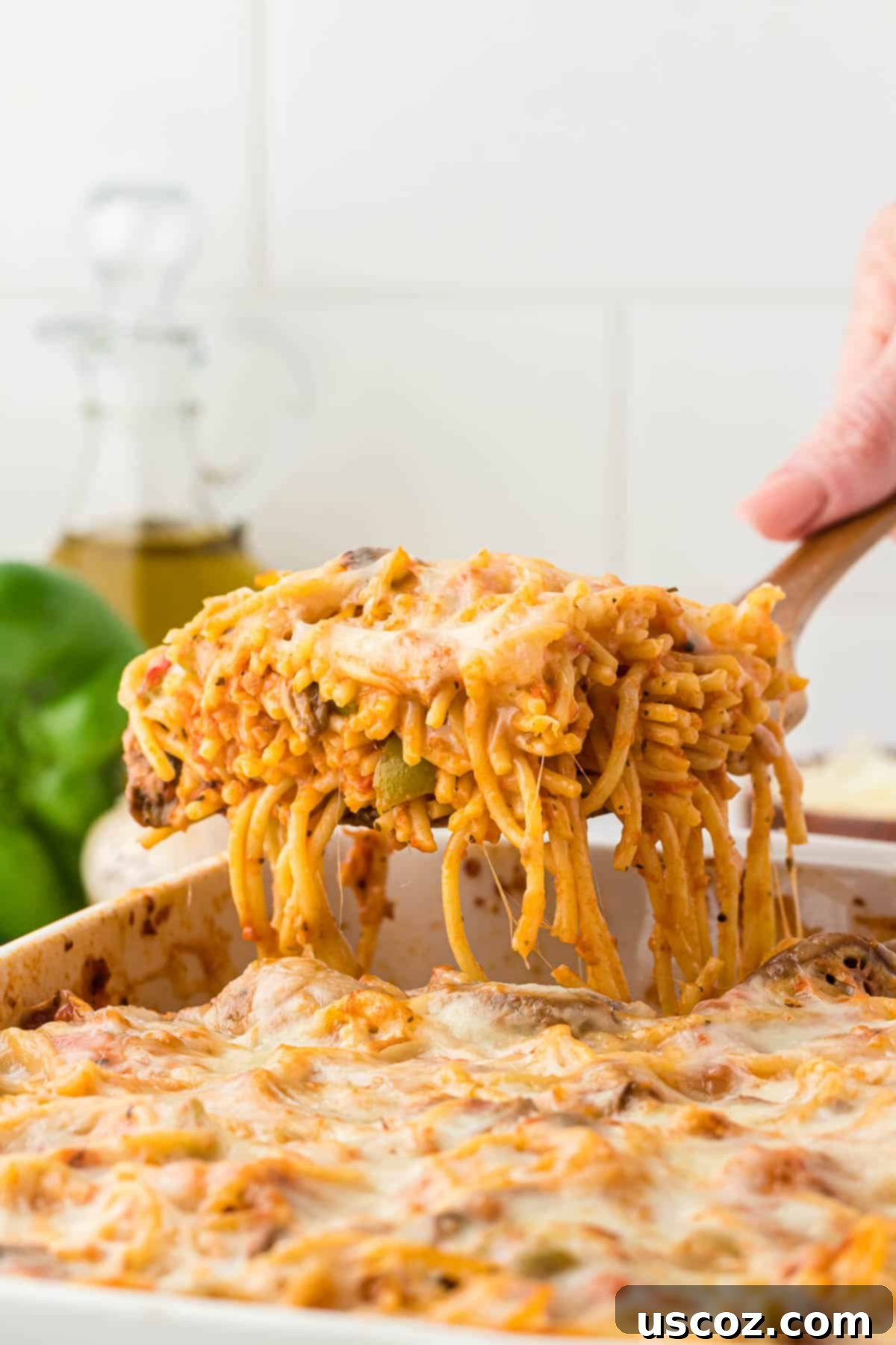 Hearty Vegetarian Spaghetti Bake 2 A generous serving of vegetarian baked spaghetti being taken from a casserole dish, showing melted cheese and rich tomato sauce