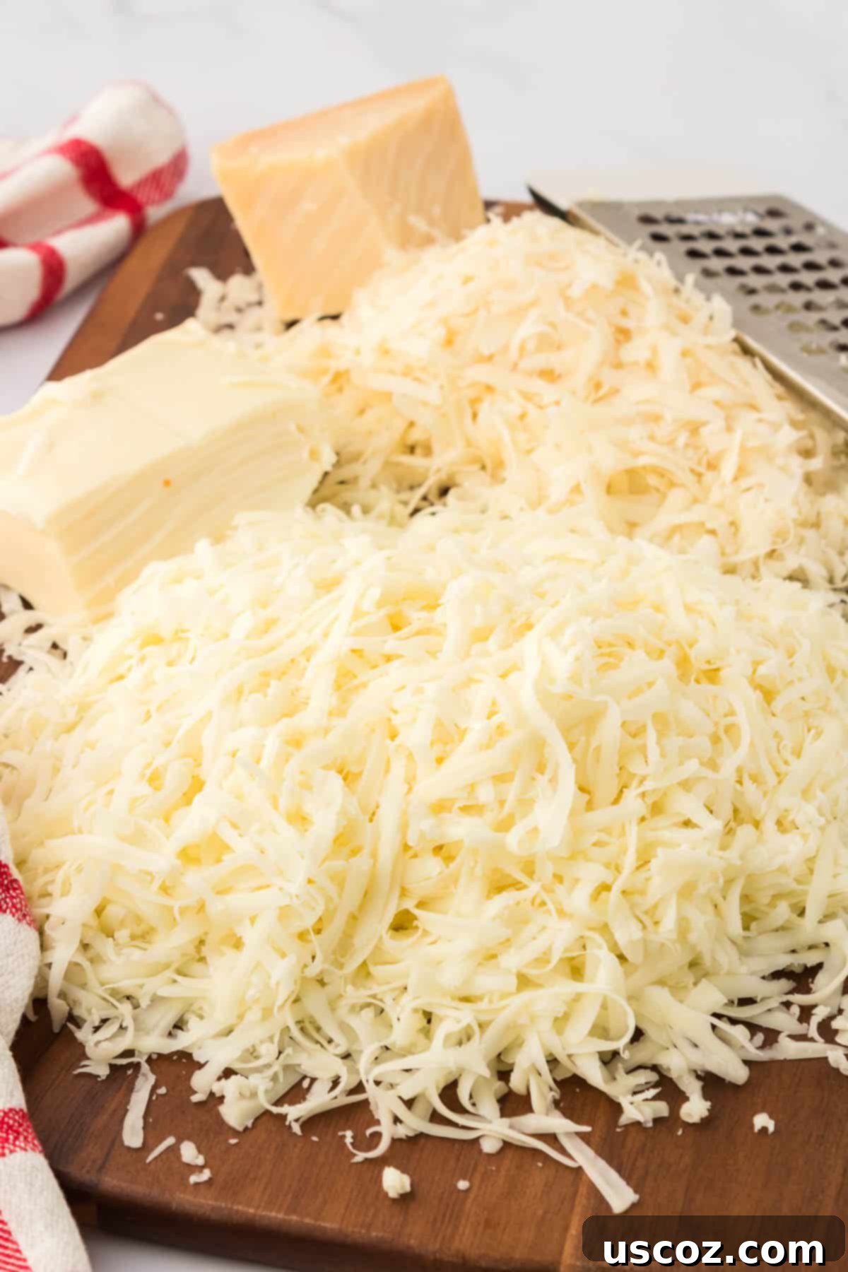 Hearty Vegetarian Spaghetti Bake 11 Grated Parmesan and shredded mozzarella cheese on a cutting board, ready for use