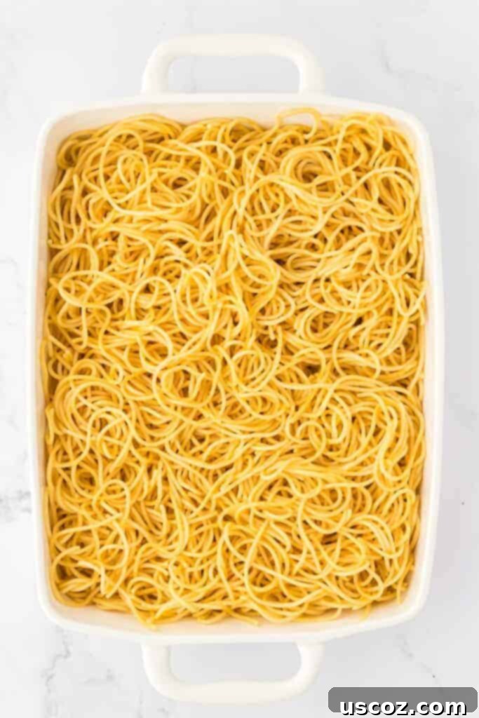 Hearty Vegetarian Spaghetti Bake 12 Cooked spaghetti spread out in a casserole dish before adding sauce and cheese
