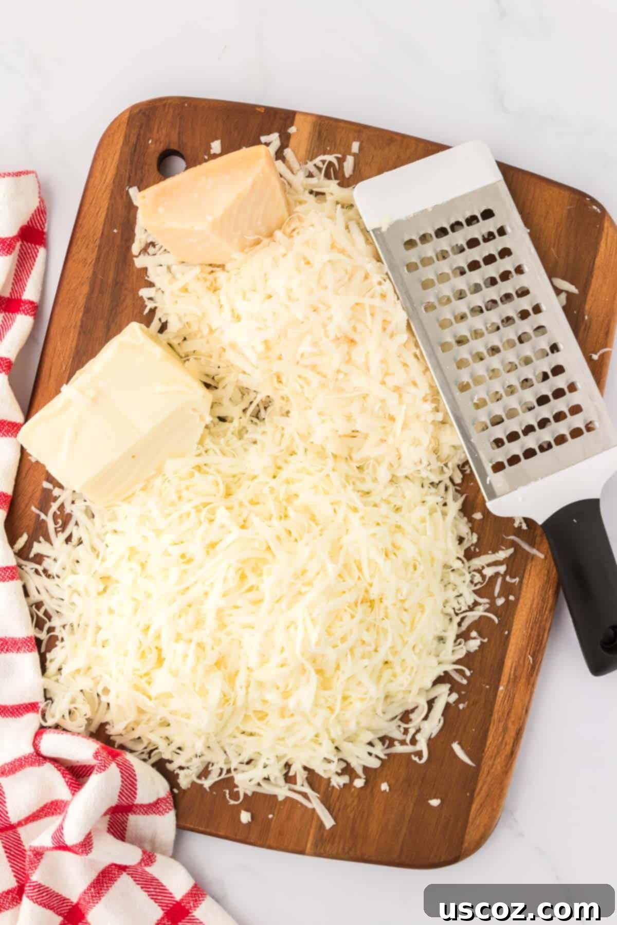 Hearty Vegetarian Spaghetti Bake 6 A pile of freshly grated Parmesan and shredded mozzarella cheese on a wooden cutting board