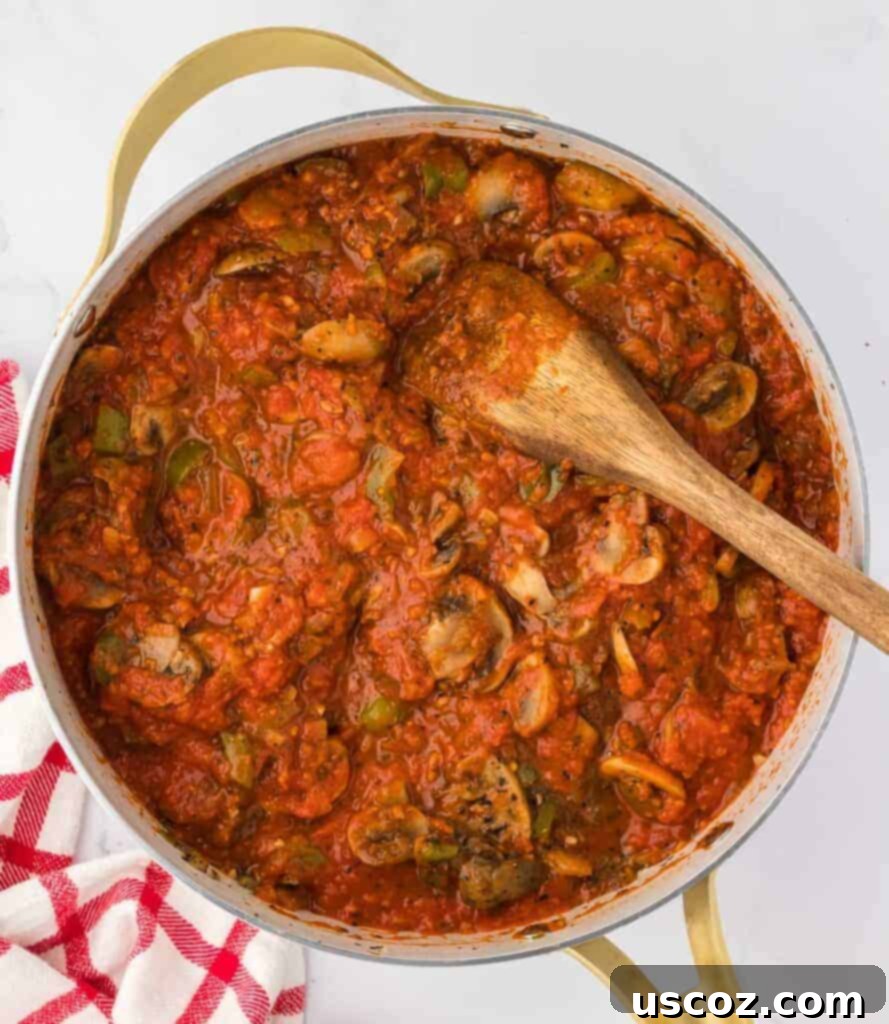 Hearty Vegetarian Spaghetti Bake 10 Close-up of vegetarian pasta sauce with cooked vegetables, stirring to combine