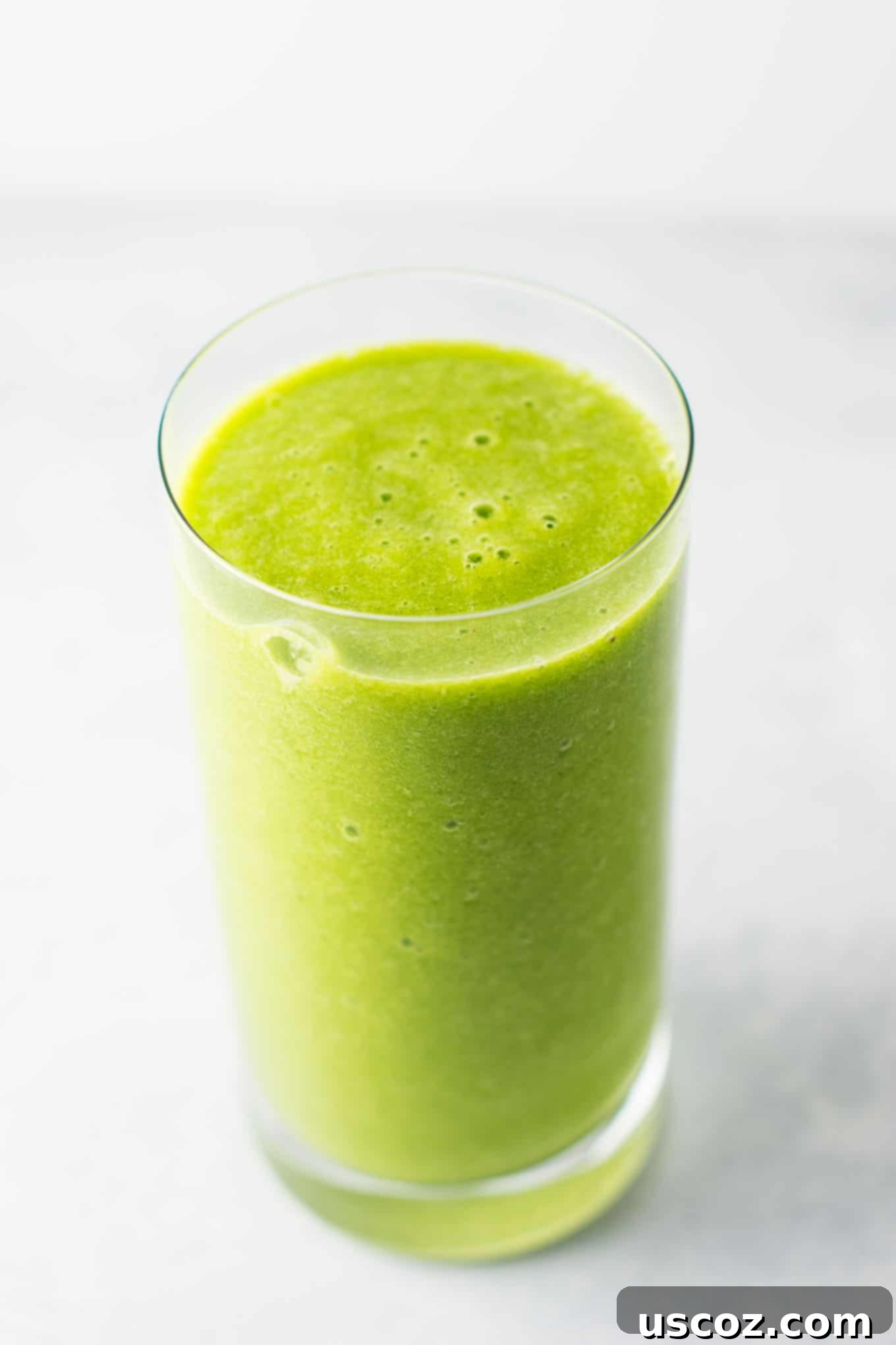 The BEST EVER green smoothie recipe made with kale, ginger, oranges, lemon, frozen banana, frozen peaches, and water. A ridiculously good for you delicious green smoothie that the whole family will love! #greensmoothierecipe #vegan #kale #drinks