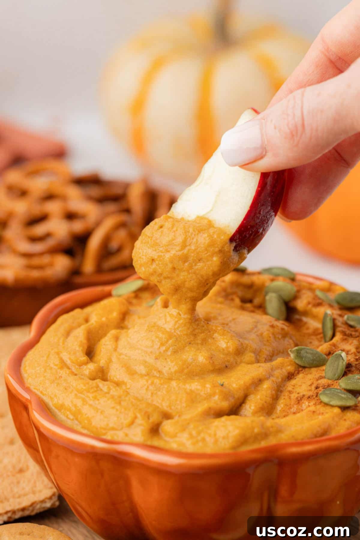 Pumpkin Cheesecake Dip 14 dipping an apple slice into pumpkin dip