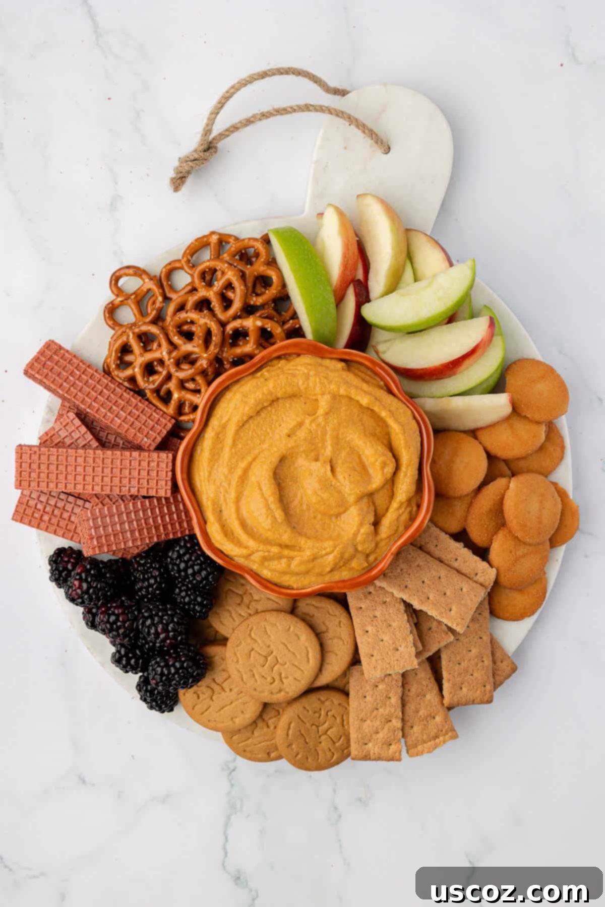 Pumpkin Cheesecake Dip 15 pumpkin dip on a board surrounded with crackers, apples, pretzels, and fruit