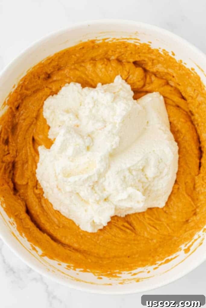 Pumpkin Cheesecake Dip 10 adding the whipped cream to the pumpkin dip