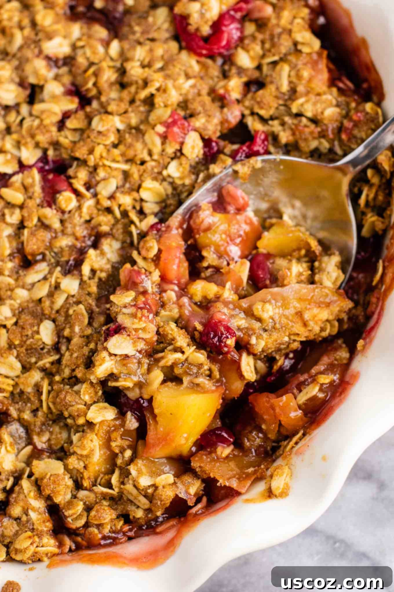 Spiced Cranberry Apple Crumble 8 A vibrant close-up of the baked cranberry apple crisp in a pie dish, highlighting the bubbly fruit and golden crisp topping.