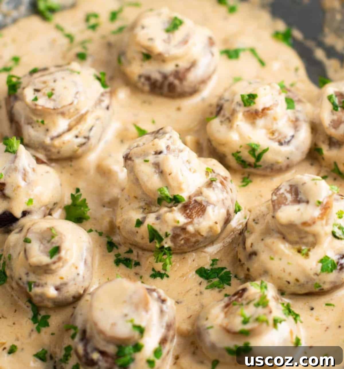 36 Delicious Vegetarian Thanksgiving Dishes 25 Portobello mushrooms in a creamy garlic sauce on a skillet, garnished with fresh parsley