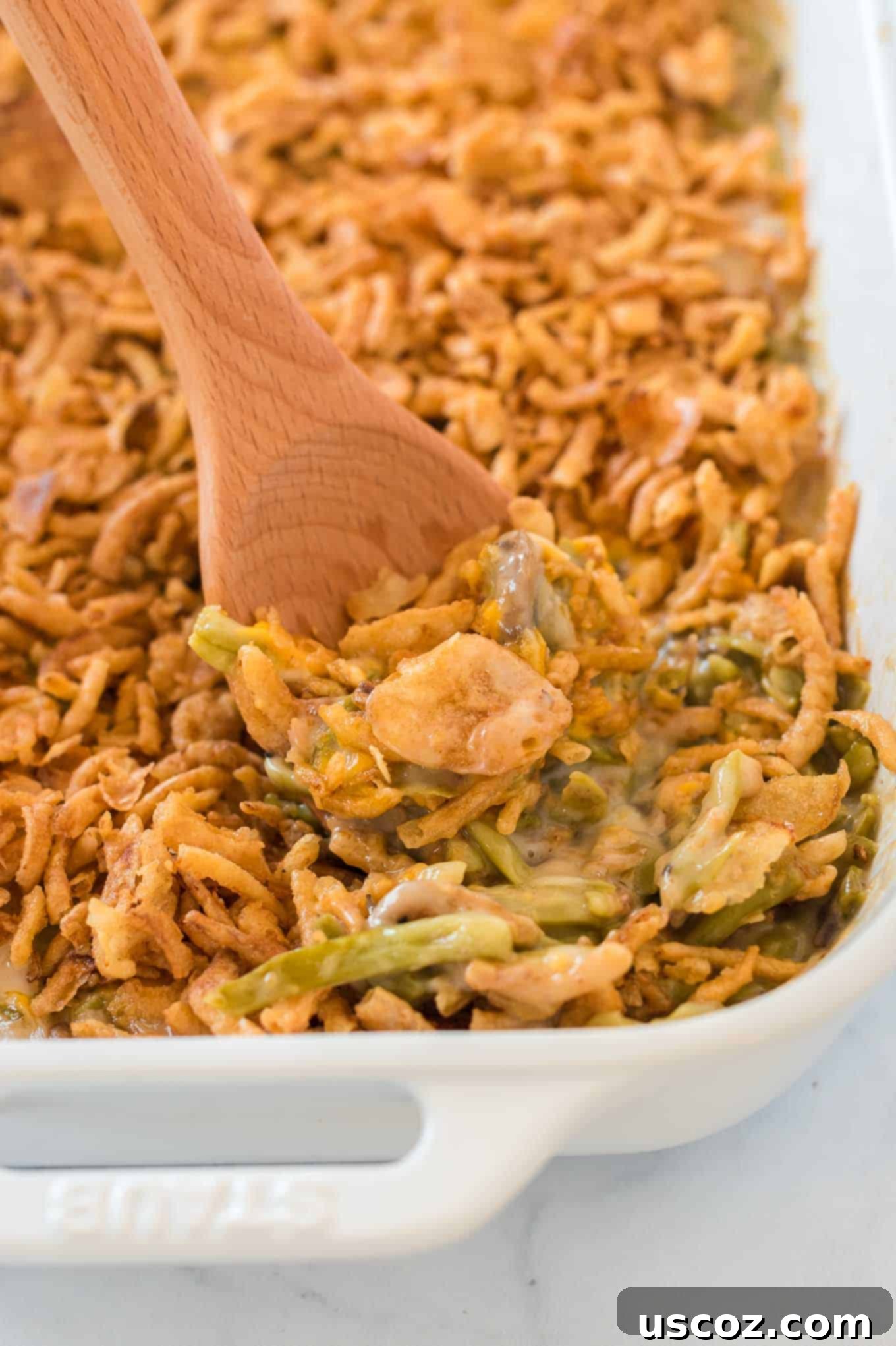 36 Delicious Vegetarian Thanksgiving Dishes 9 Green bean casserole in a baking dish, with a wooden spoon ready to serve