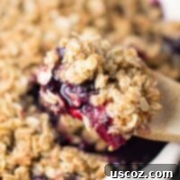 A delicious gluten-free vegan blueberry peach crisp recipe via @buildyourbite, showcasing a golden brown topping and juicy fruit filling.