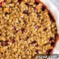 A beautiful cranberry apple crisp, showcasing its golden topping and juicy, vibrant fruit filling, ready to be served.