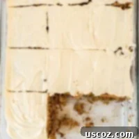 A delectable gluten-free carrot cake sliced with two pieces removed, showcasing its moist texture and rich cream cheese frosting.
