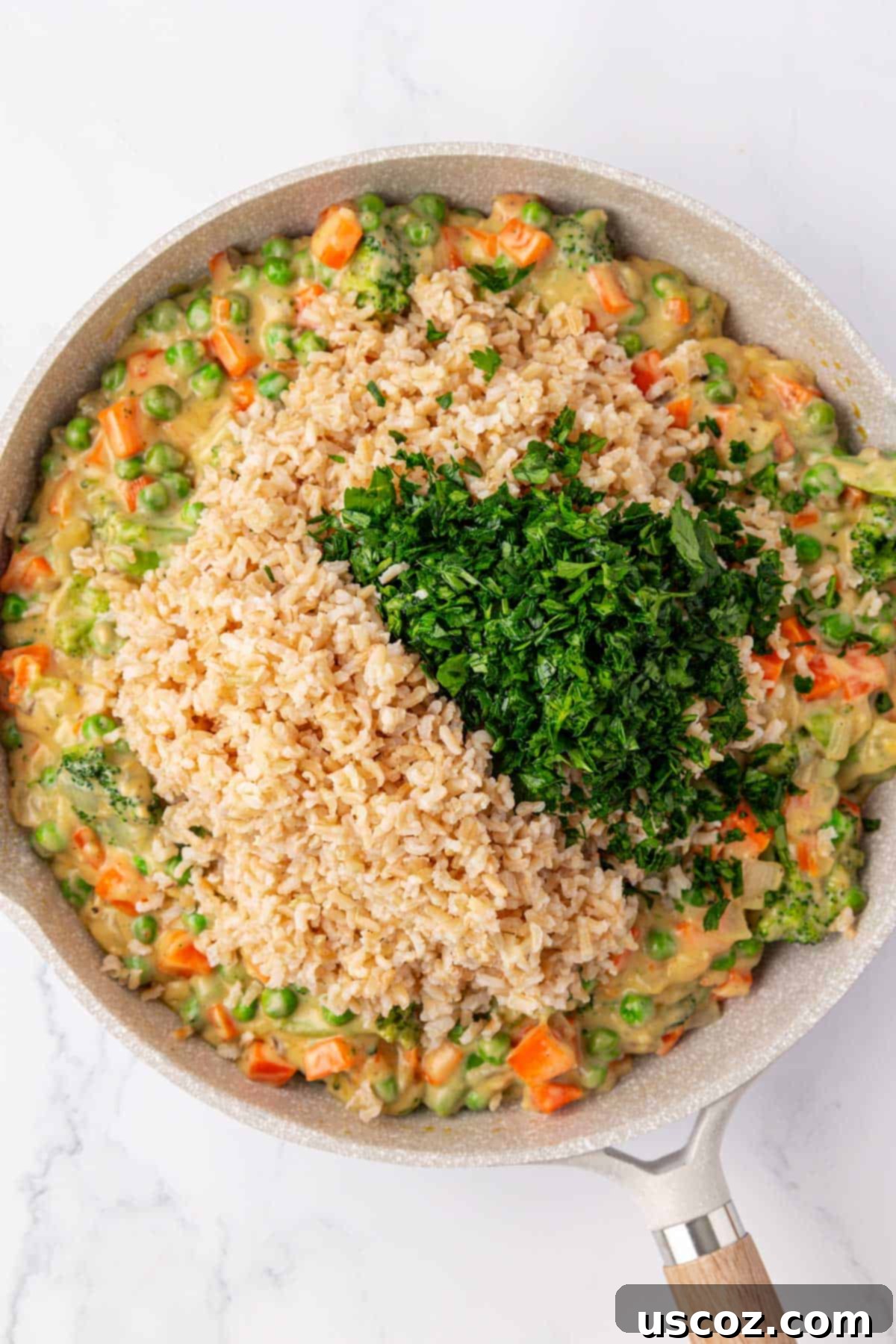 Hearty Veggie Rice Bake 11 Cooked rice and fresh parsley being stirred into the creamy vegetable mixture