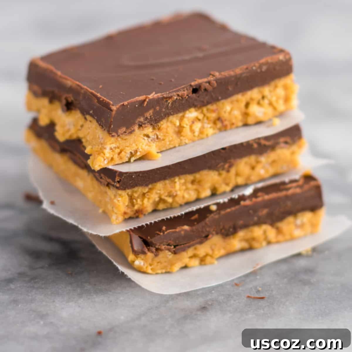 Easy No-Bake Chocolate Peanut Butter Bars 2 Stacked delicious no-bake chocolate peanut butter bars, separated by wax paper, ready to be enjoyed.