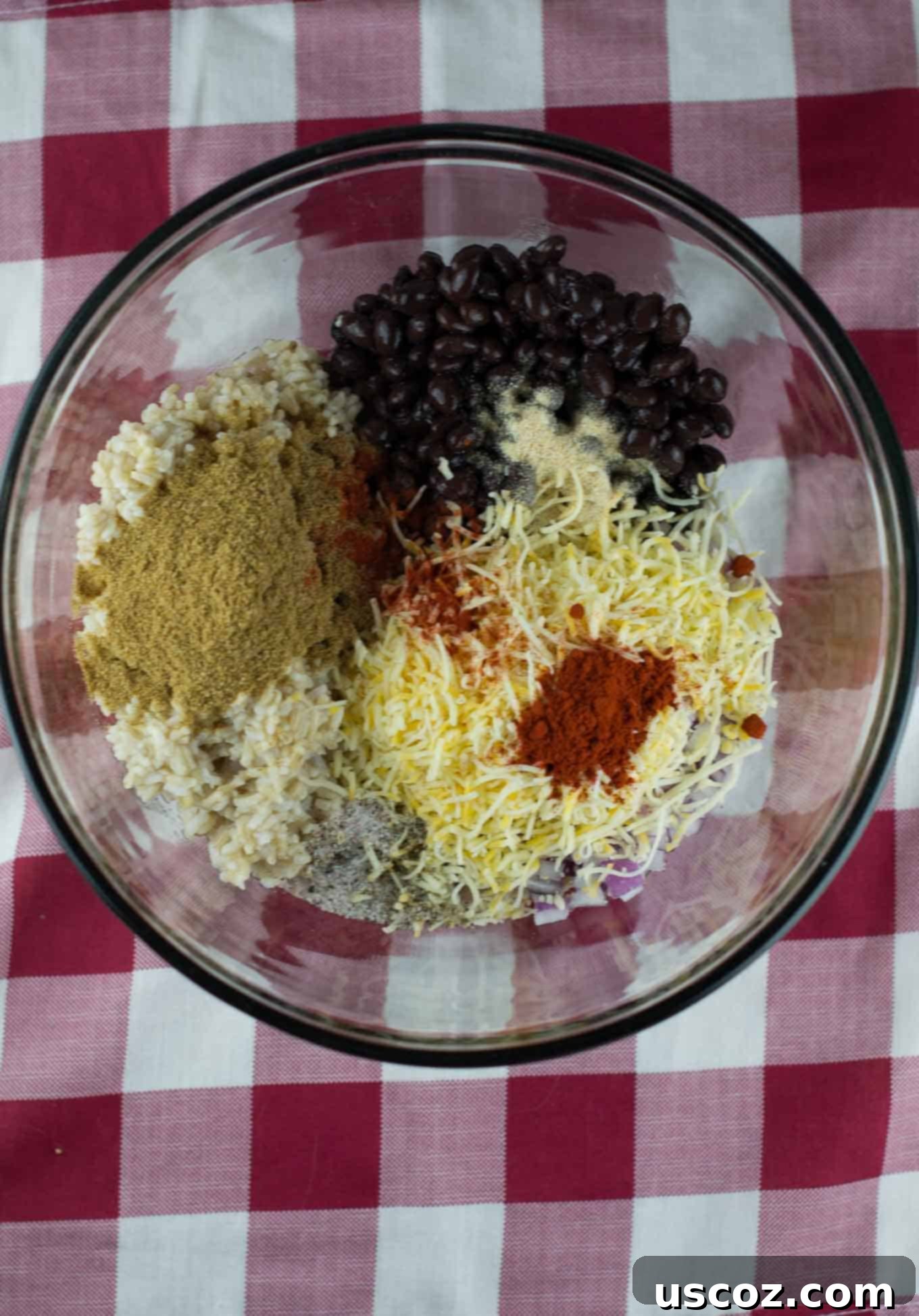 Bowl with black beans, shredded Mexican cheese, and diced red onion for the filling